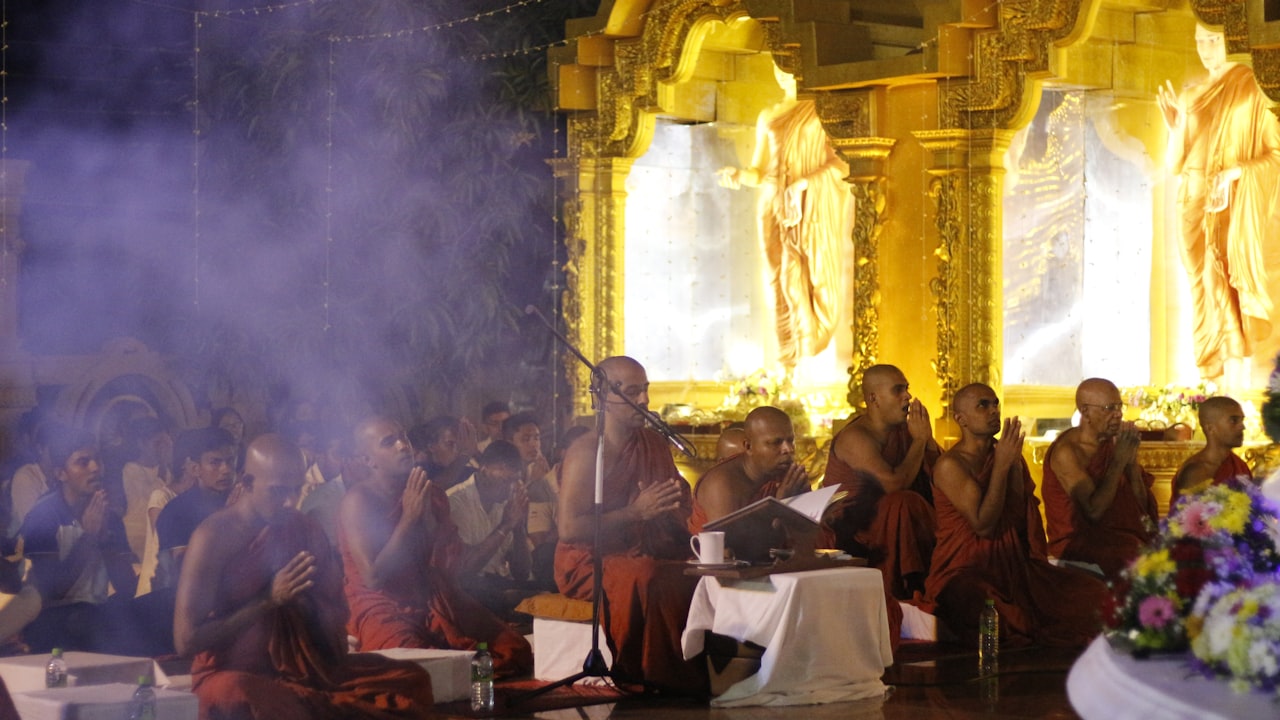 A rank of robed figures standing in silence in a dim, smoke-filled hall